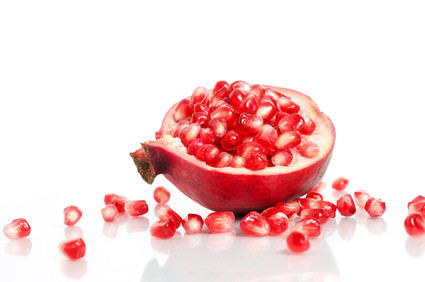 Pomegranate with seeds over white